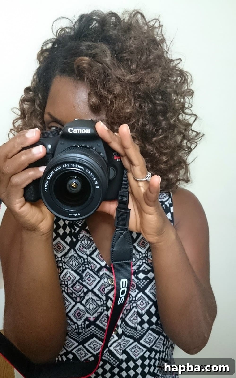 Excited blogger holding new Canon EOS Rebel T5 DSLR camera.