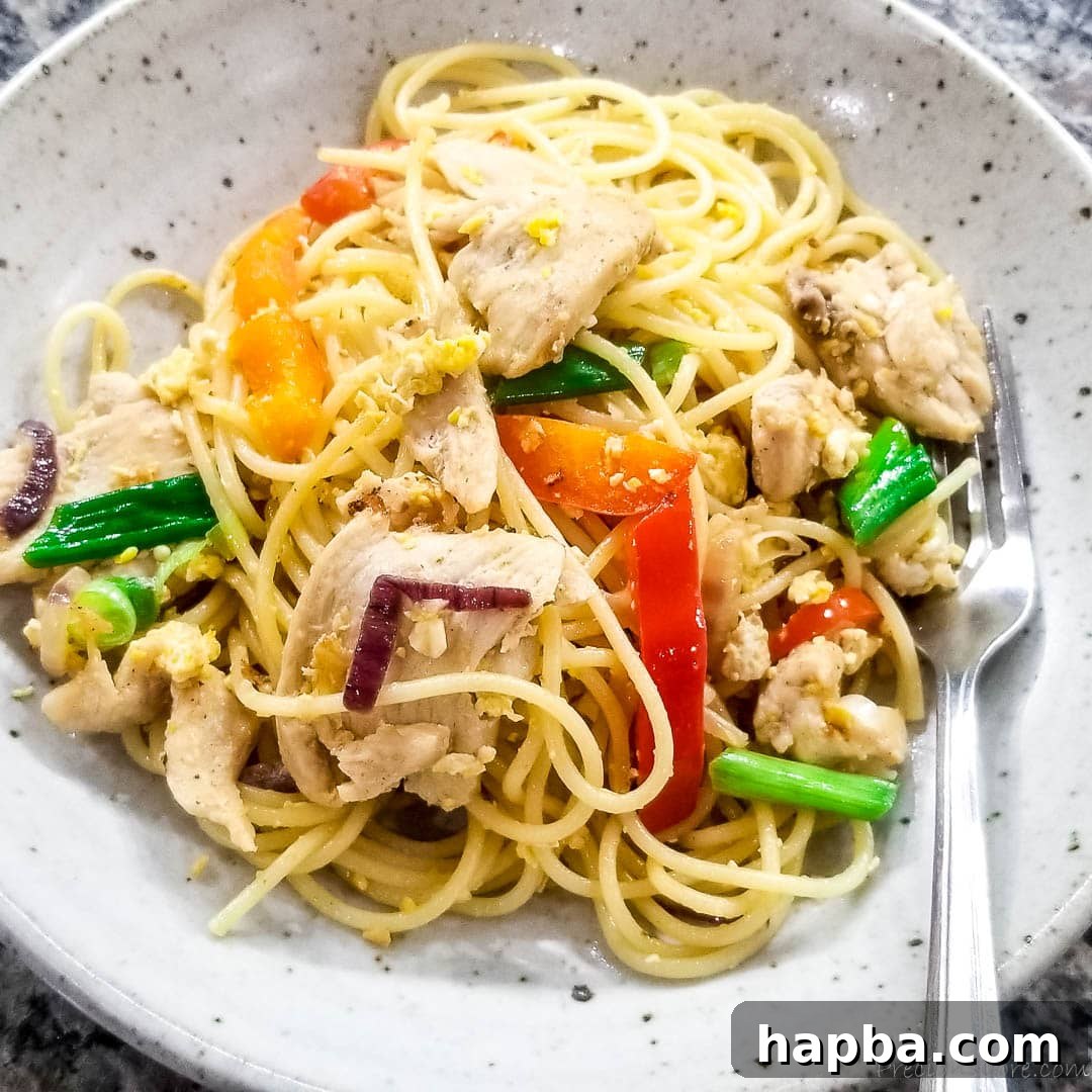 A serving of spaghetti stir fry plated beautifully, garnished with fresh green onions, ready to be enjoyed as a complete meal.