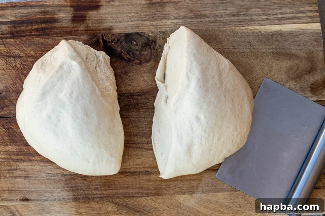 Effortless Homemade Sandwich Bread 7 Two neatly divided portions of soft bread dough resting on a clean chopping board, ready for shaping into loaves.