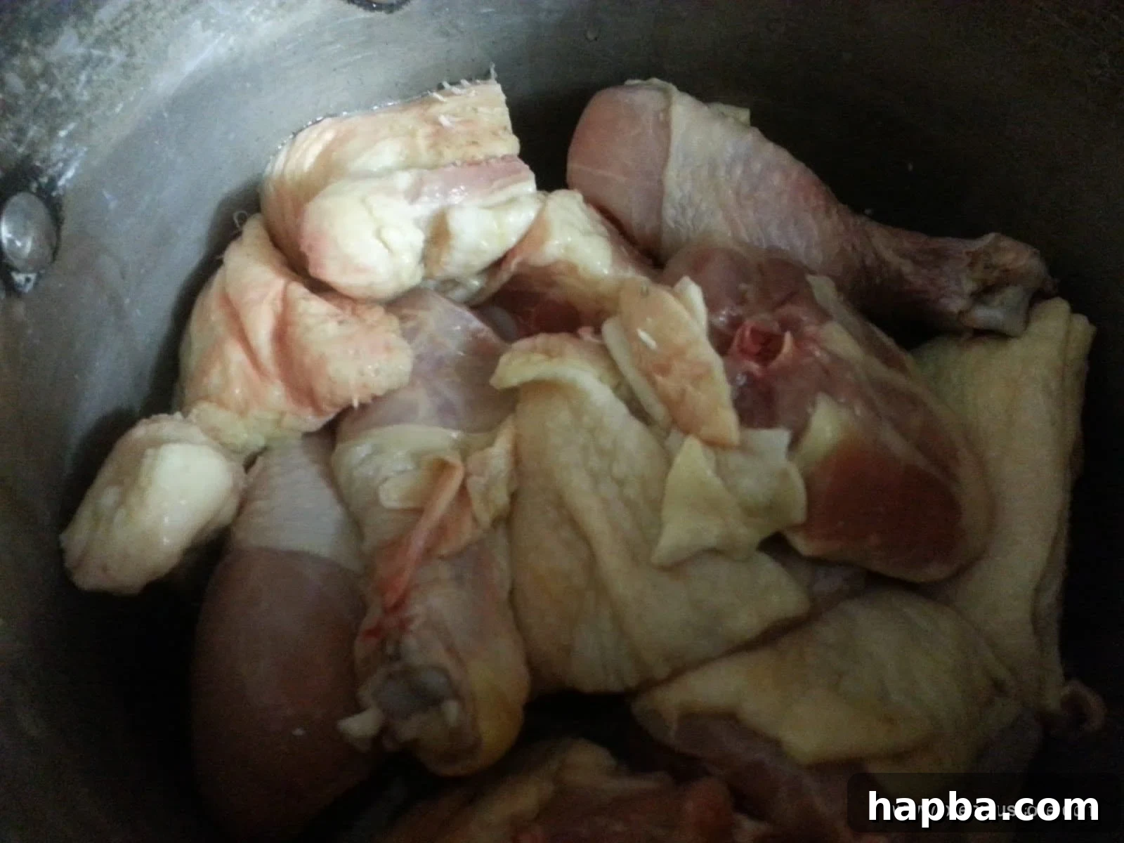 Chicken Prepped for Seasoning Cleaned and portioned chicken pieces resting in a pot, ready for seasoning