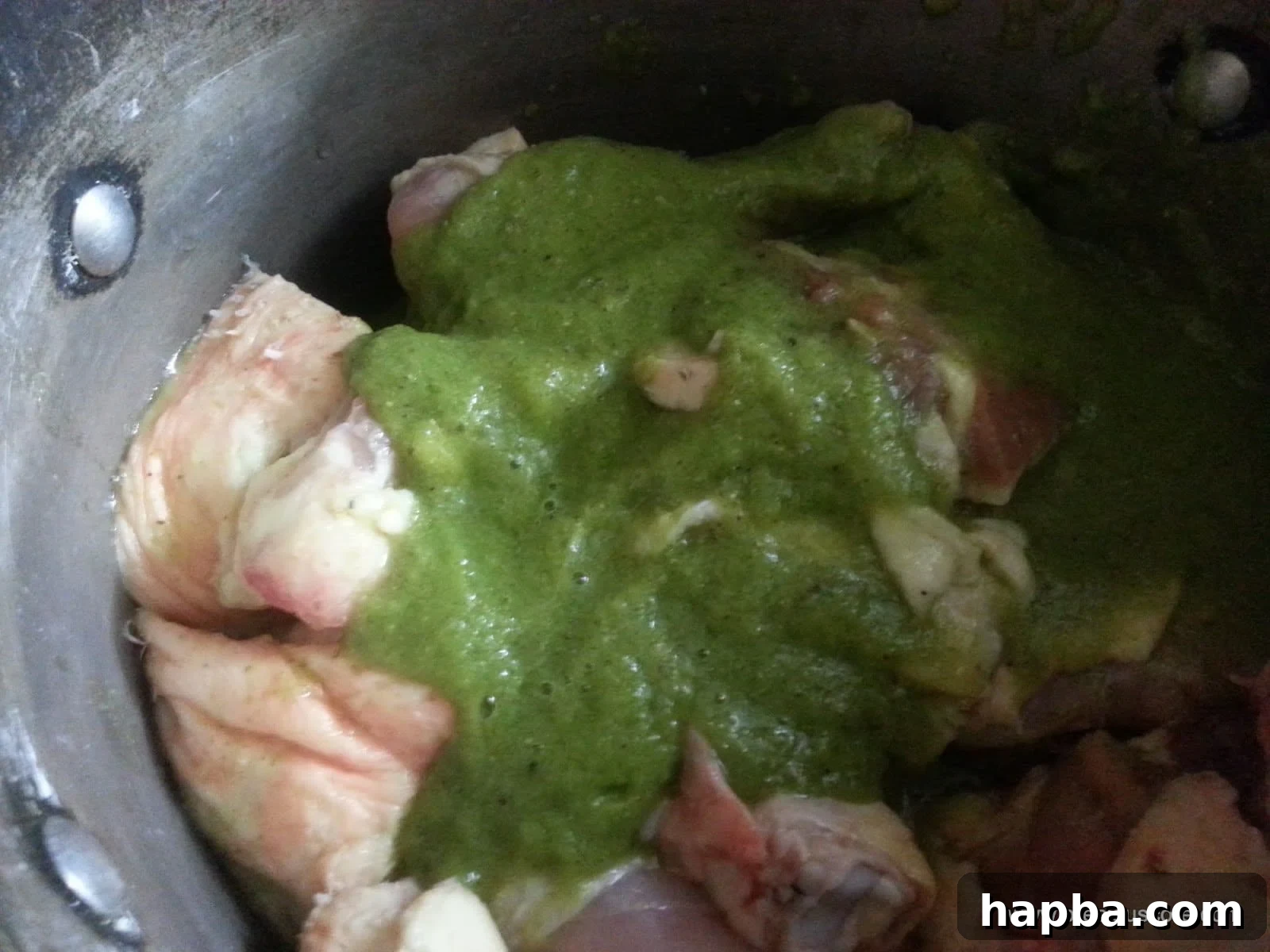 Marinating Chicken with Fresh Spices Freshly blended aromatic spices and herbs poured over chicken pieces in a pot