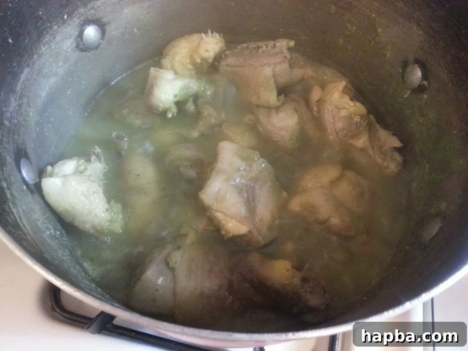 Chicken Pre-Boiling in Seasoned Stock Chicken simmering in a pot with aromatic spices and herbs, pre-cooking process