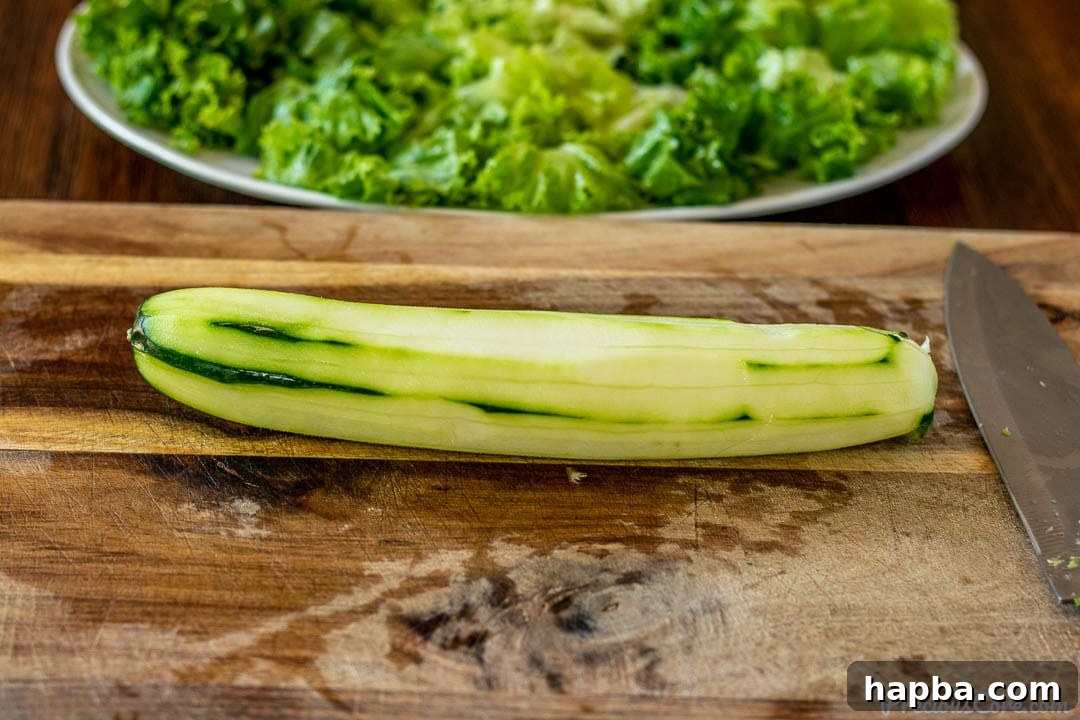 A freshly peeled garden cucumber on a rustic chopping board, ready to be sliced for the salad.