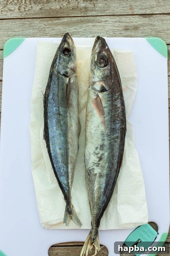 Two fresh whole fish, expertly cleaned and placed on a wooden cutting board, ready for slicing into steaks.