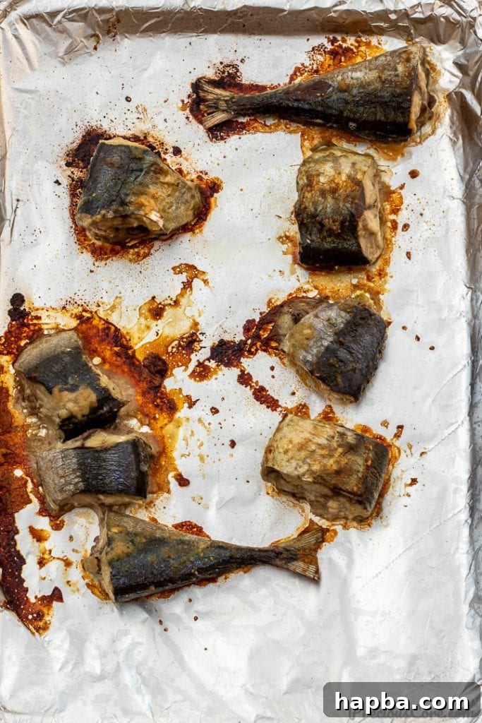 Evenly baked fish steaks laid out on a baking sheet, ready to be added to the stew.