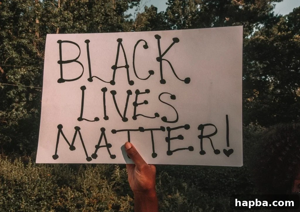 Black hand holding a "Black Lives Matter" placard