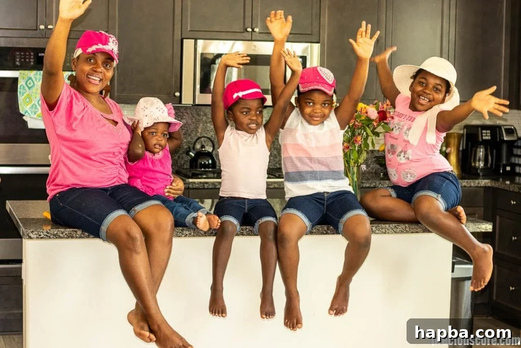 Nurturing Love: Parenting with Heart 3 A mother and her four daughters share a joyful moment in the kitchen, engaged in a cooking activity together.