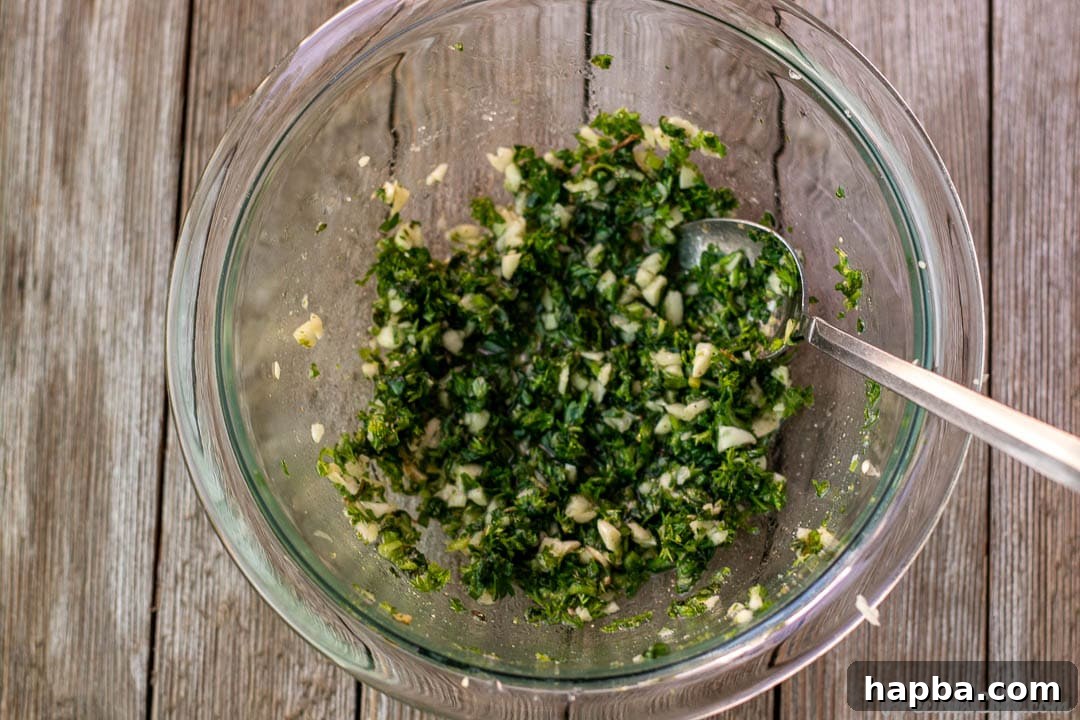 A vibrant green herb and garlic marinade mixture in a mixing bowl, ready to be applied to the fish.