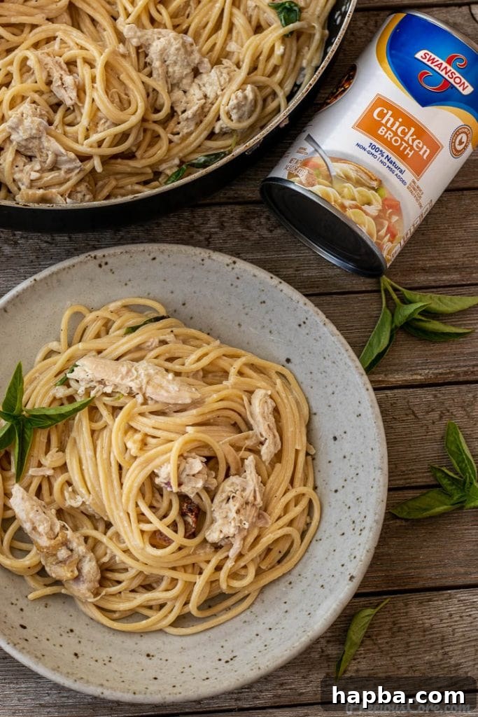 Hearty Weeknight Chicken Spaghetti 4 spaghetti and chicken in a bowl, can of chicken broth nearby