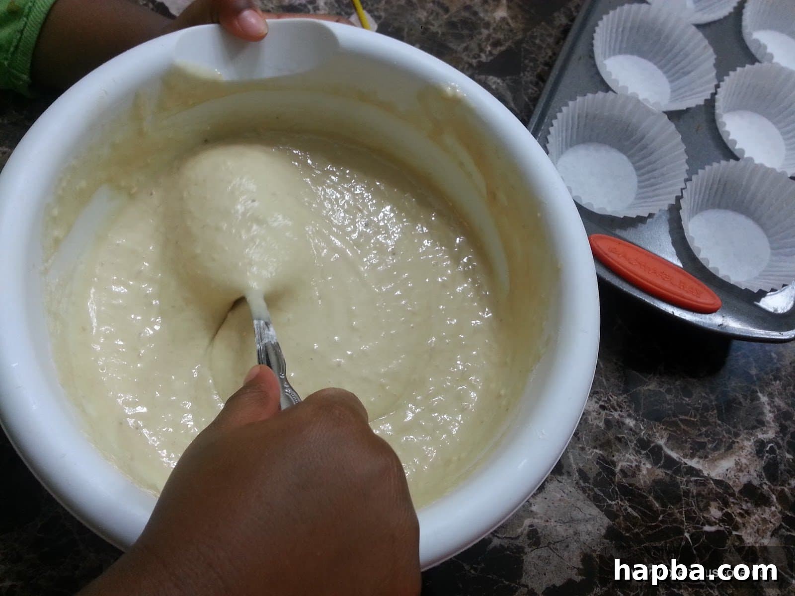 A spoon gently stirring the banana cake batter until all ingredients are just combined.
