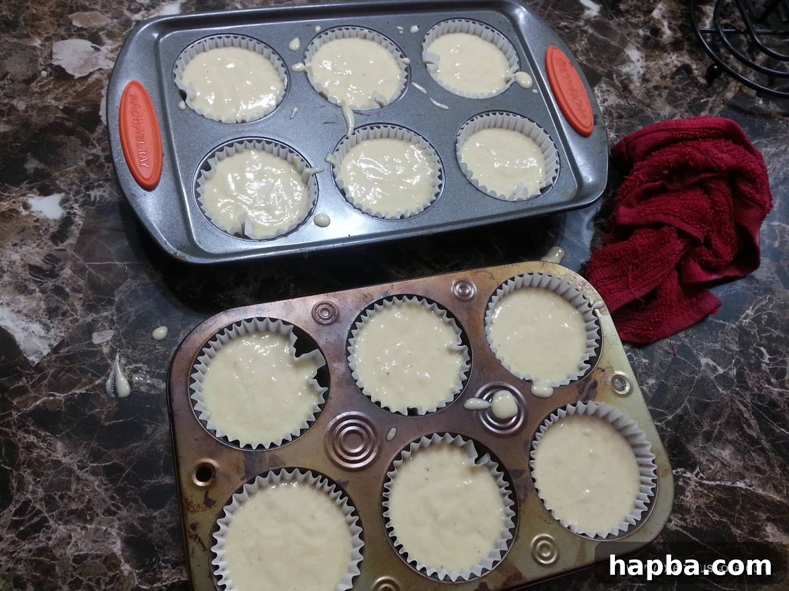 Muffin pans filled evenly with uncooked banana cake batter, ready for the oven.
