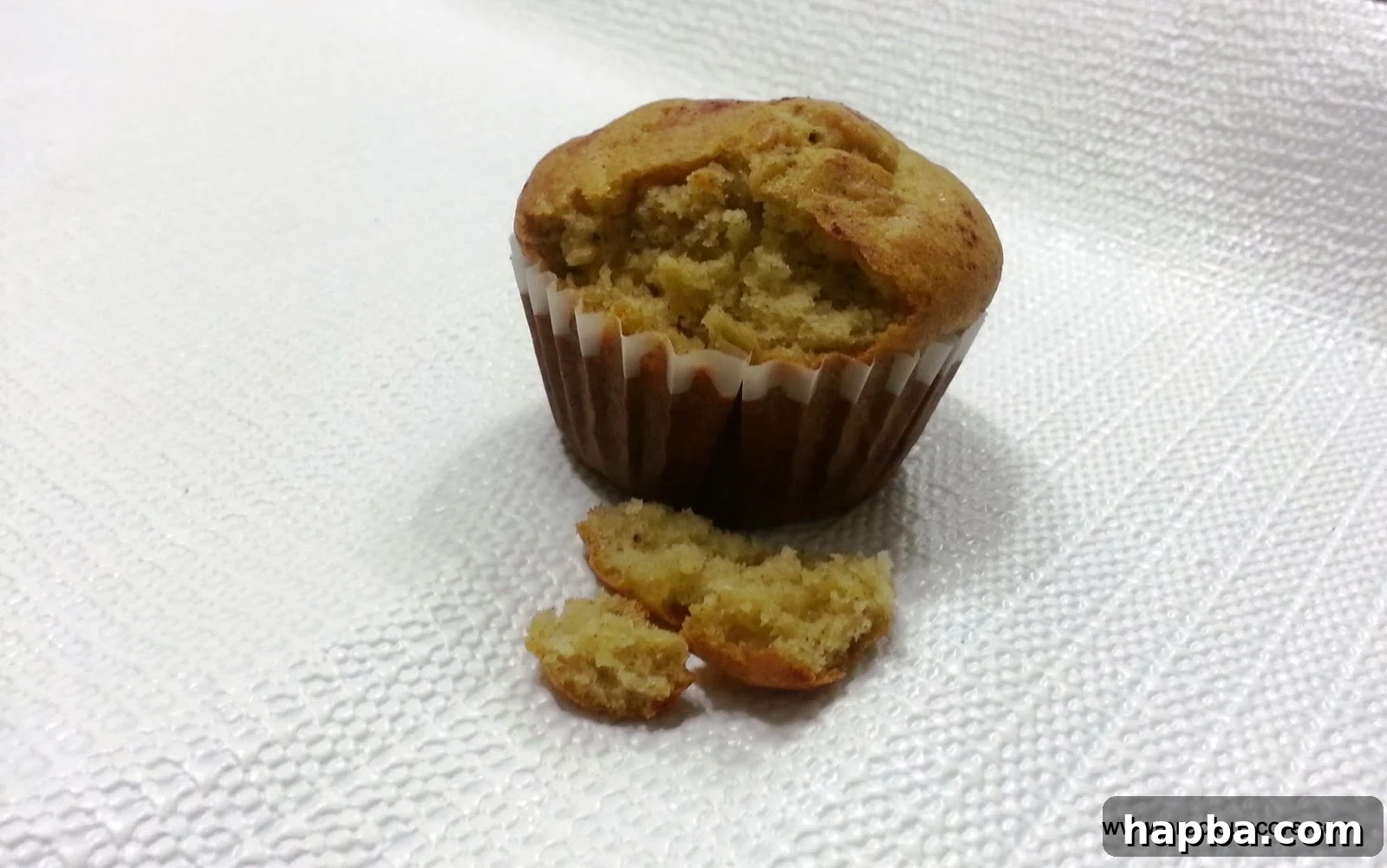 A partially crumbled Cameroonian banana cake, revealing its moist, tender interior.