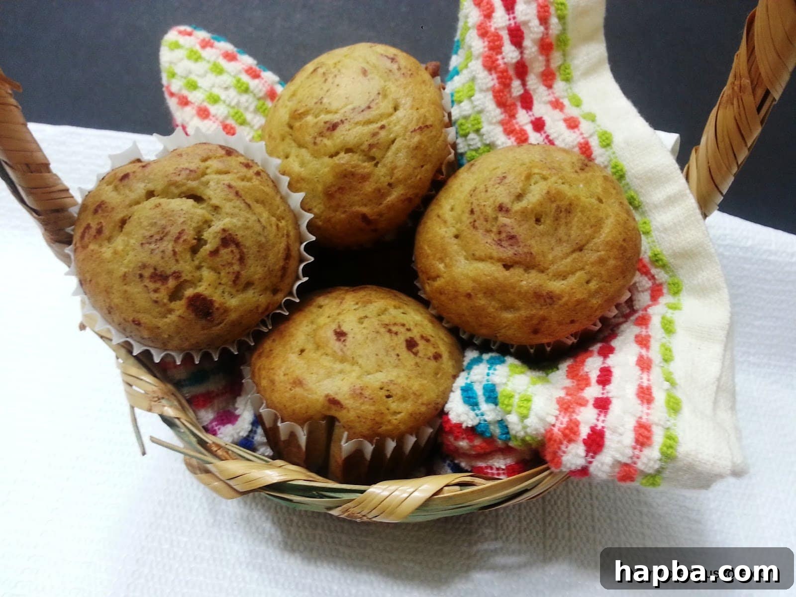 A charming display of Cameroonian banana cakes nestled on a patterned cloth in a rustic basket, ready for serving.