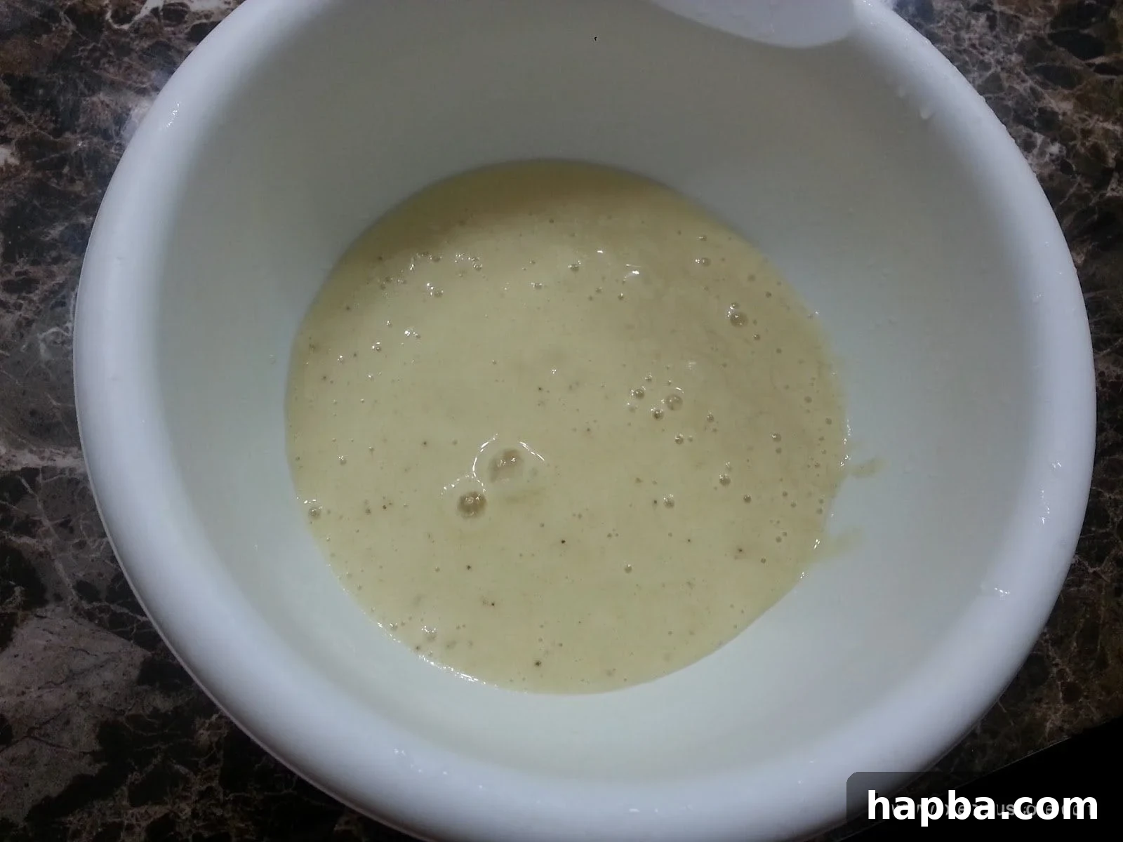 Smooth banana mixture with liquid in a single mixing bowl.