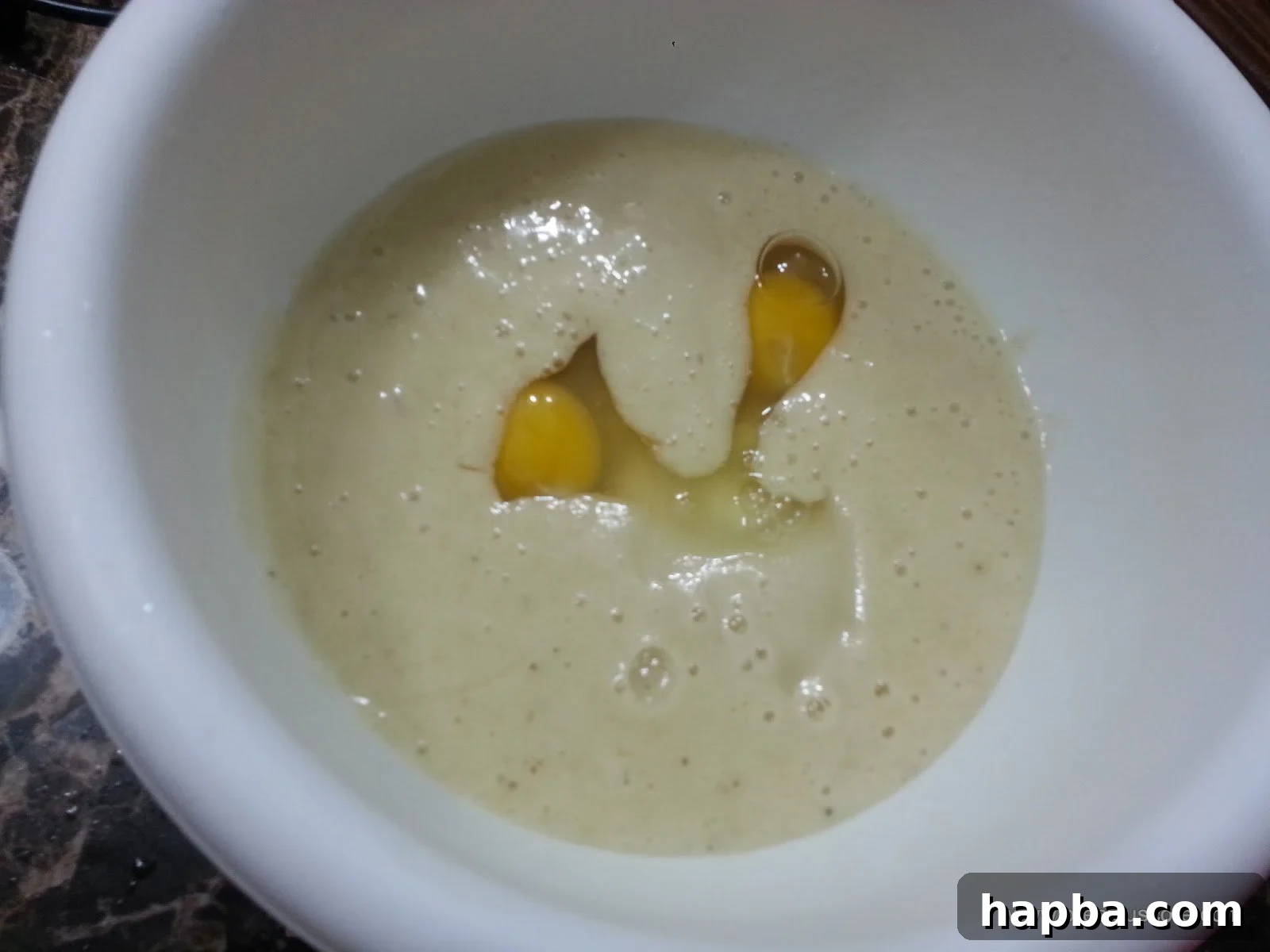 Eggs added to the banana mixture in a mixing bowl.