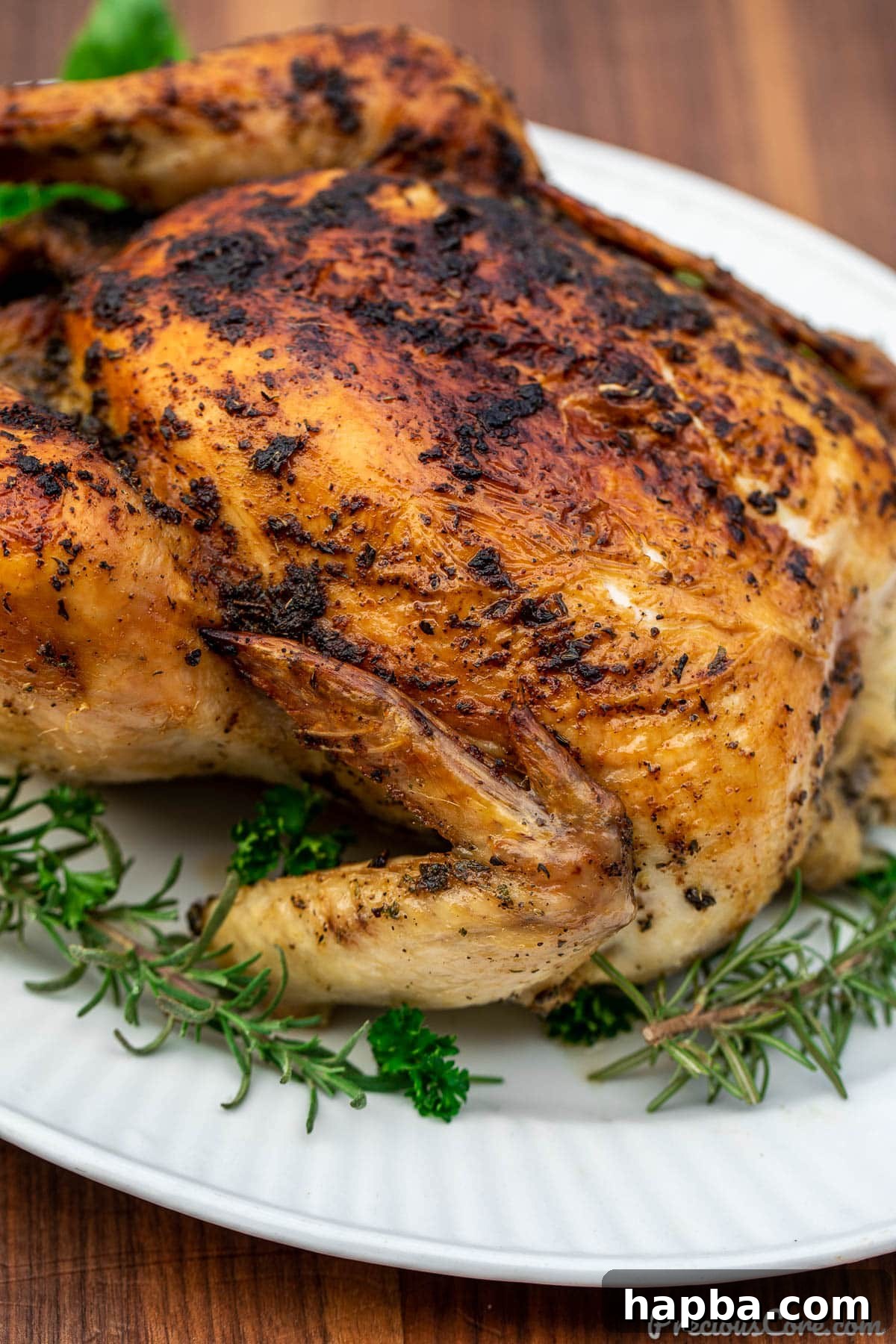 Succulent Herb Roasted Chicken 3 Close-up shot showing one side of golden roasted chicken, highlighting its crispy skin and succulent appearance.