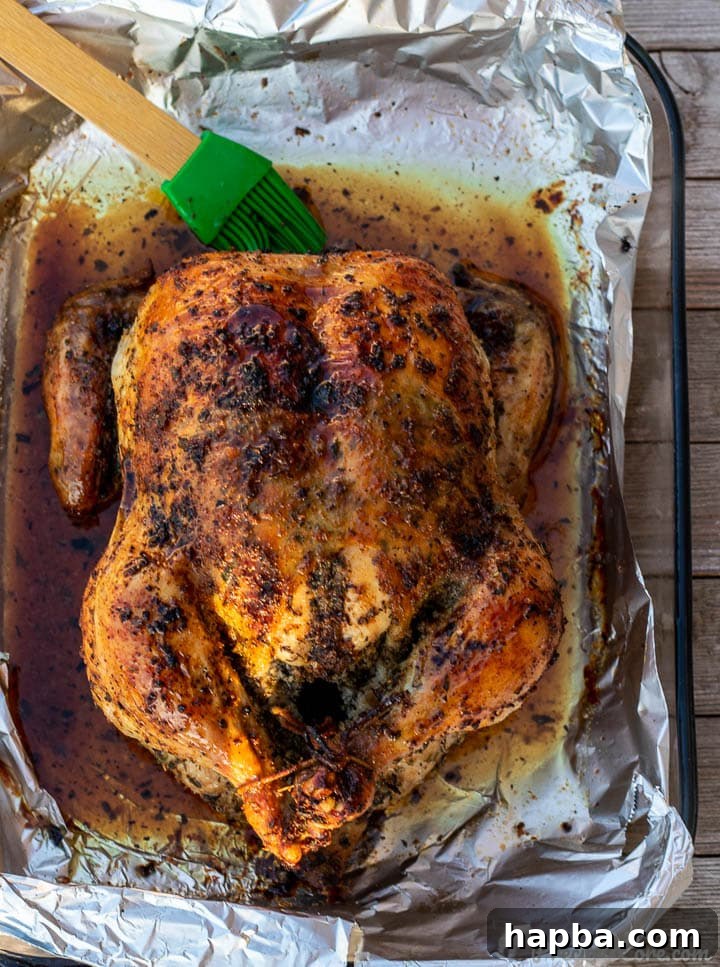 Succulent Herb Roasted Chicken 7 A golden brown roast chicken, fresh out of the oven, still in its baking dish, appearing incredibly juicy.