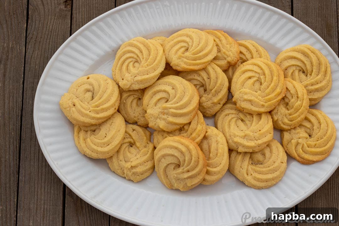 A stunning landscape photo showcasing the golden perfection of Danish Butter Cookies, some still on the cooling rack.