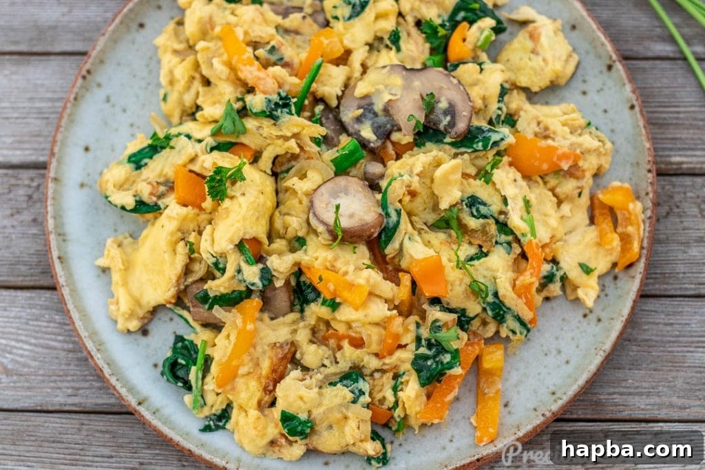 Colorful Morning Scramble 5 A vibrant, close-up landscape shot of freshly made scrambled eggs with an array of colorful vegetables, showcasing their fluffy texture.