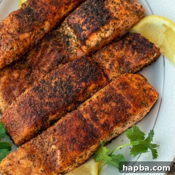 Four grilled salmon fillets on a serving platter