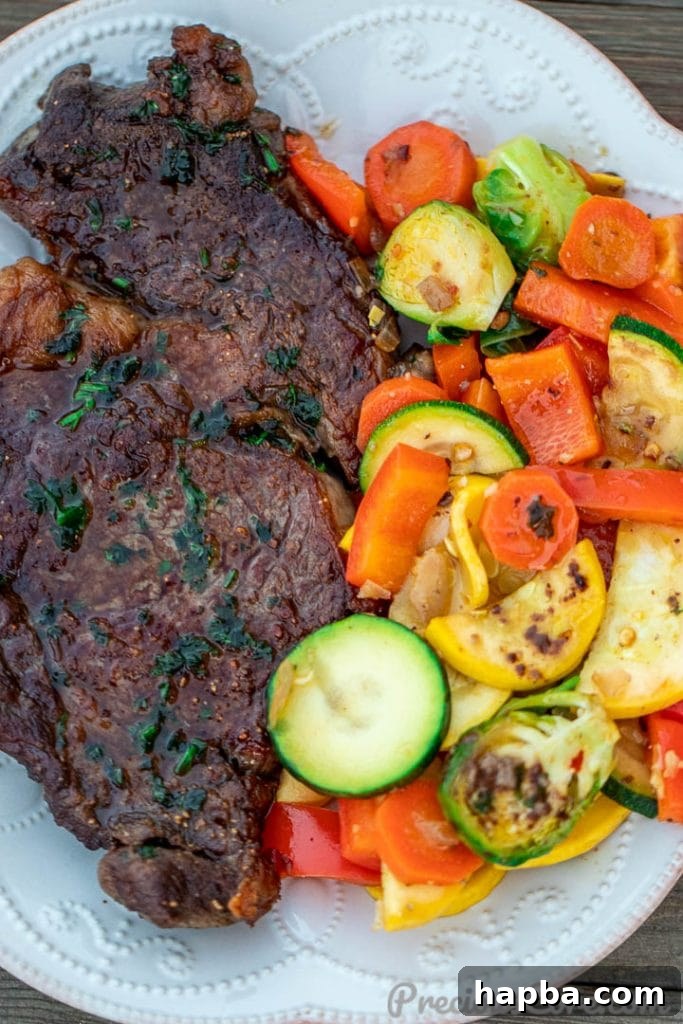 A beautifully plated dish featuring pan-seared ribeye steak sliced and served alongside colorful sautéed vegetables on a white plate.