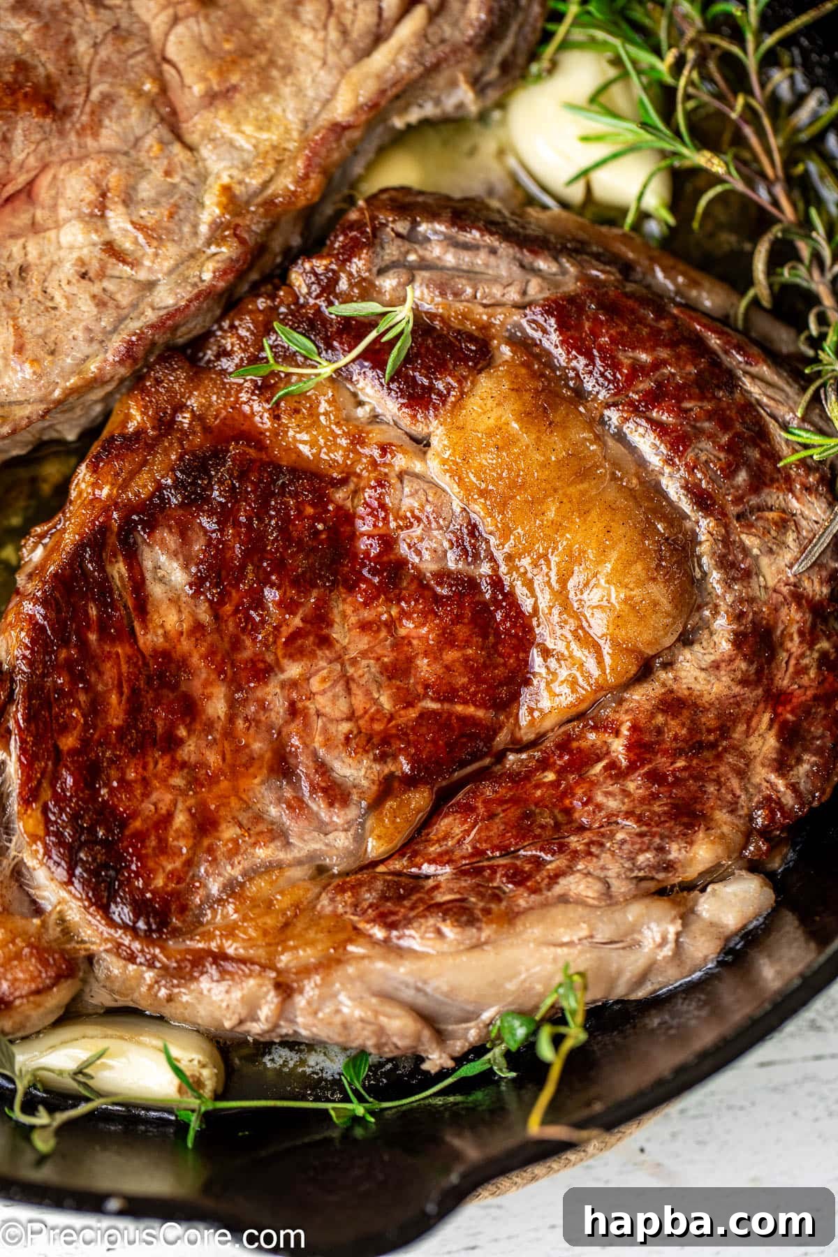Close-up shot of a perfectly cooked pan-seared ribeye, showcasing its beautiful internal pinkness and appealing texture.