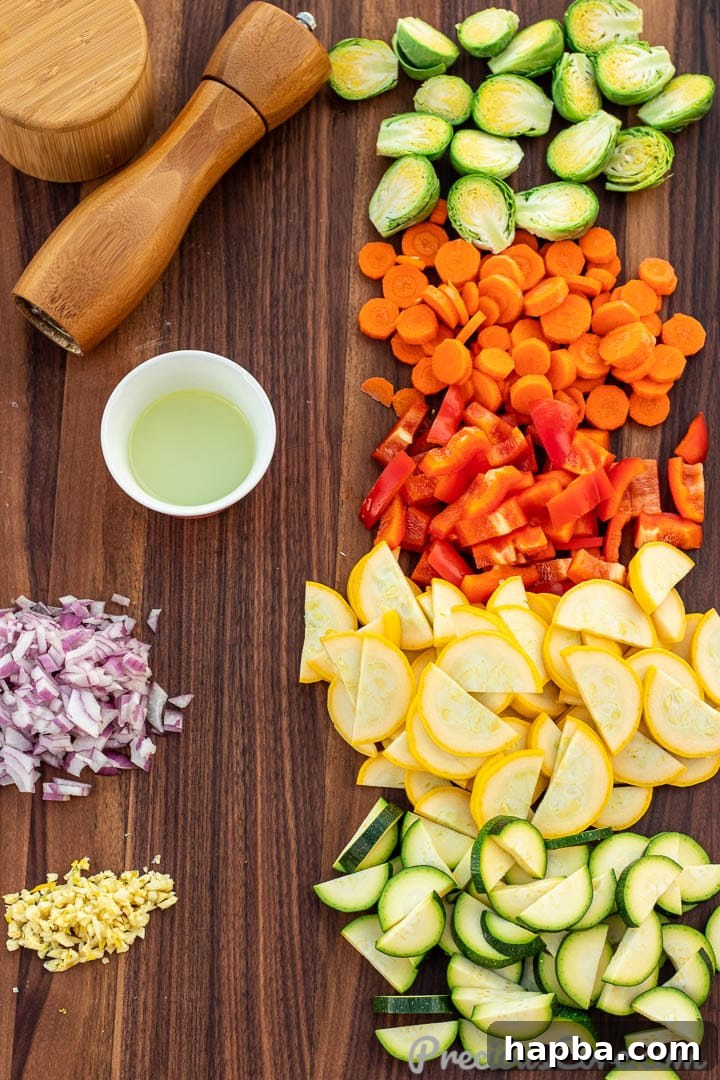 Ingredients for sautéed vegetables laid out on a cutting board, including carrots, bell peppers, zucchini, and onions