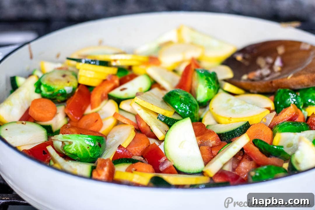 All the prepped vegetables, including Brussels sprouts, carrots, bell peppers, zucchini, and yellow squash, combined in a large pot.