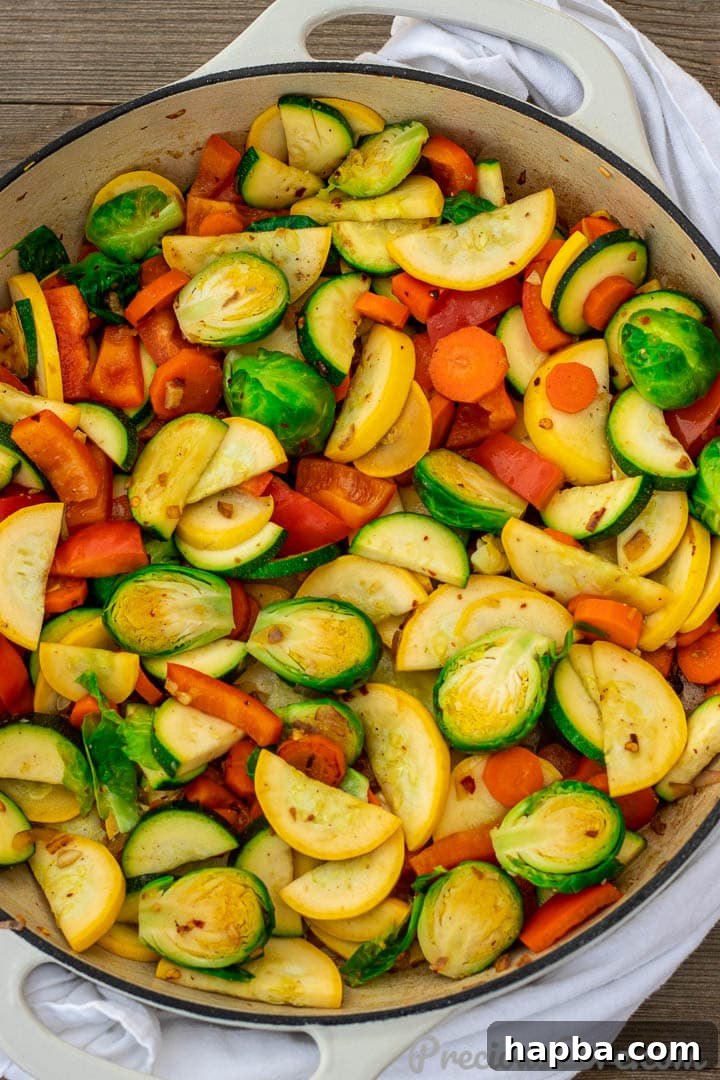 A large pot filled with freshly sautéed vegetables, perfectly cooked and vibrant.