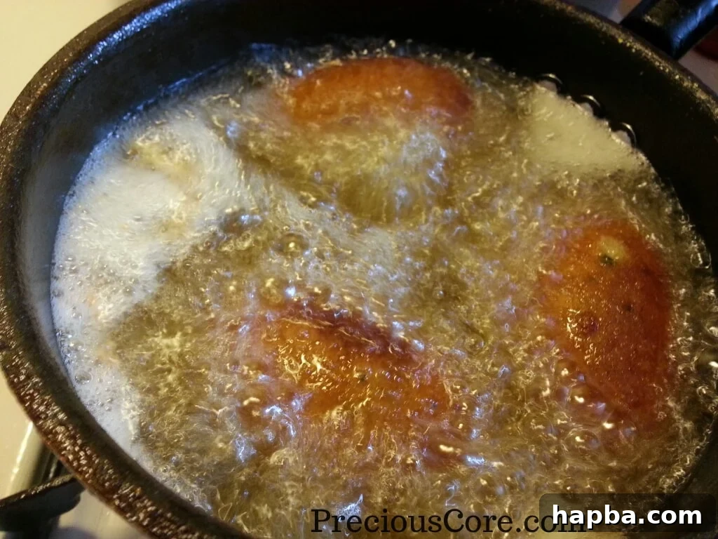 Fish Scotch Eggs deep frying in hot vegetable oil