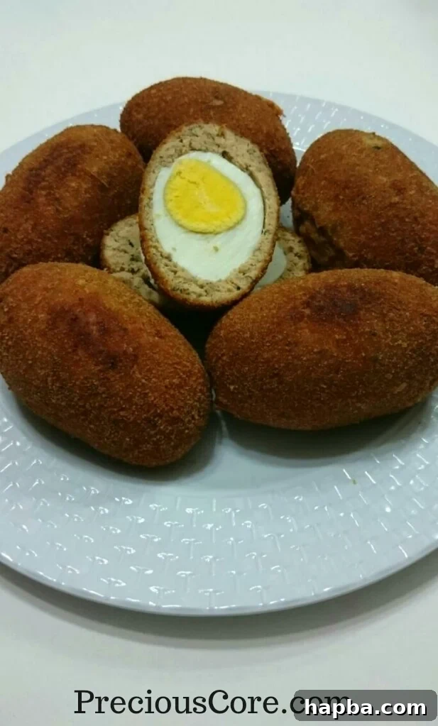 Freshly prepared fish-coated Scotch Eggs ready for frying