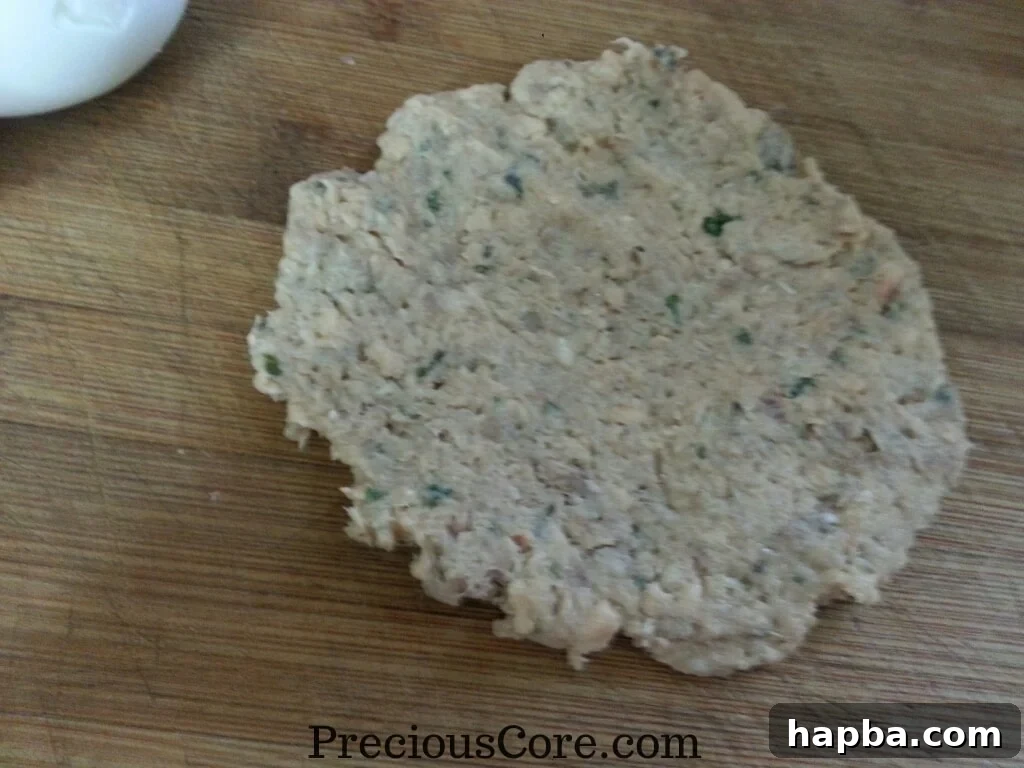 Flattened fish mixture ready to receive a hard-boiled egg
