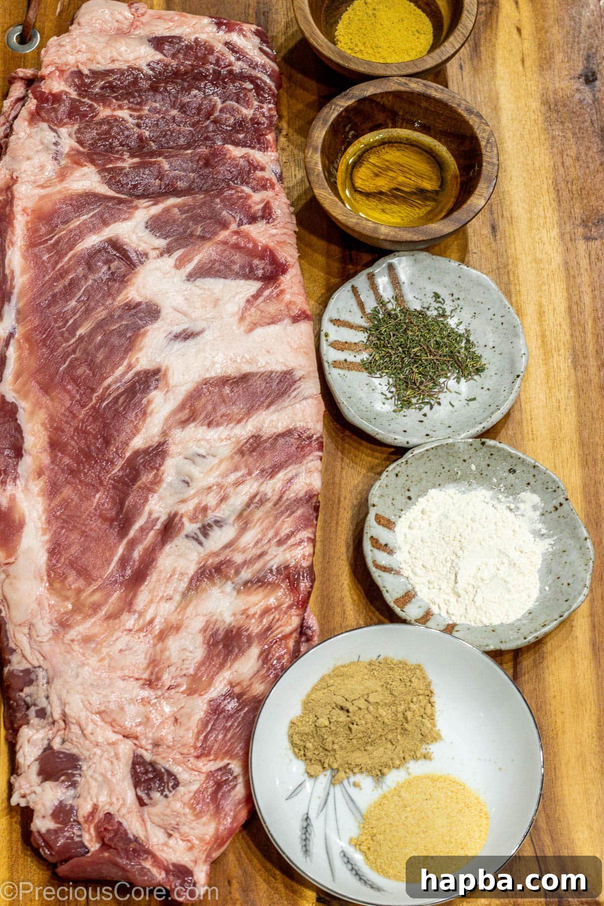 Tender Dry-Rubbed Ribs 3 Raw spare ribs on a cutting board, surrounded by bowls of various spices and salt.