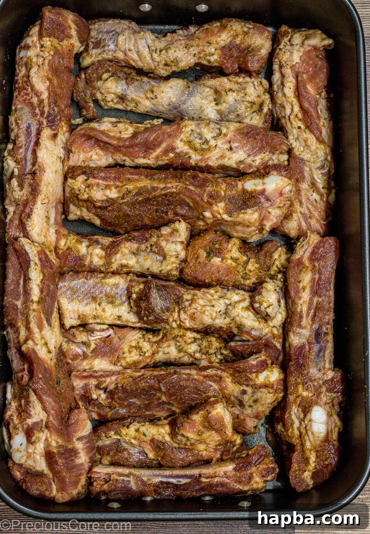 Tender Dry-Rubbed Ribs 6 Seasoned dry rub ribs arranged neatly in a baking dish, ready for the oven.