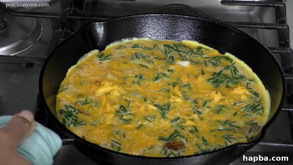 Hearty Potato Egg Bake 10 The Potato Frittata mixture, including eggs, potatoes, mushrooms, and cheese, settling on the stovetop in a skillet before baking.