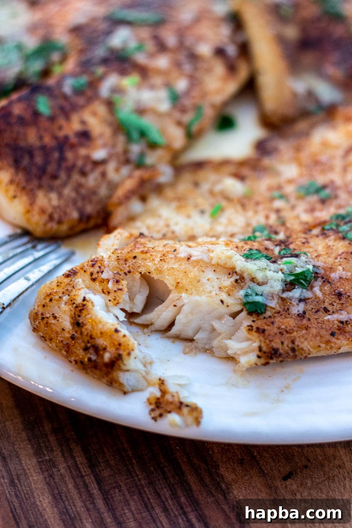 Zesty Lemon Butter Tilapia 3 Close-up of flaky Lemon Butter Tilapia fish, showing texture and delicious sauce.
