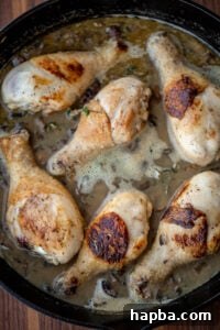 Chicken drumsticks simmering in a rich mushroom and herb sauce.