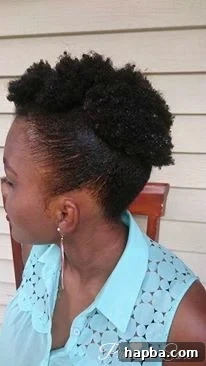 A woman with her natural hair styled into a sleek mohawk, showcasing defined curls.