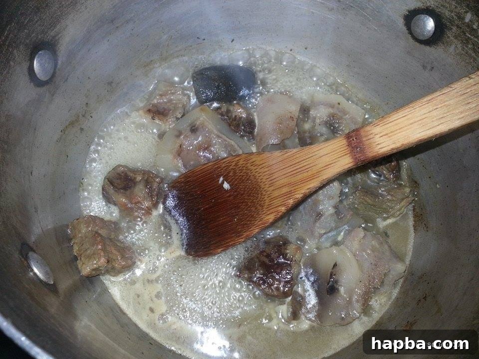 Crafting Delicious Okra Egusi Soup 4 Boiled beef and canda (beef skin) in a pot, ready for the soup
