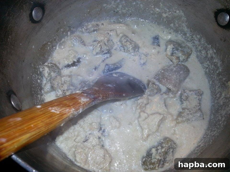 Crafting Delicious Okra Egusi Soup 5 Ground Egusi mixed with water, forming a thick paste in the pot