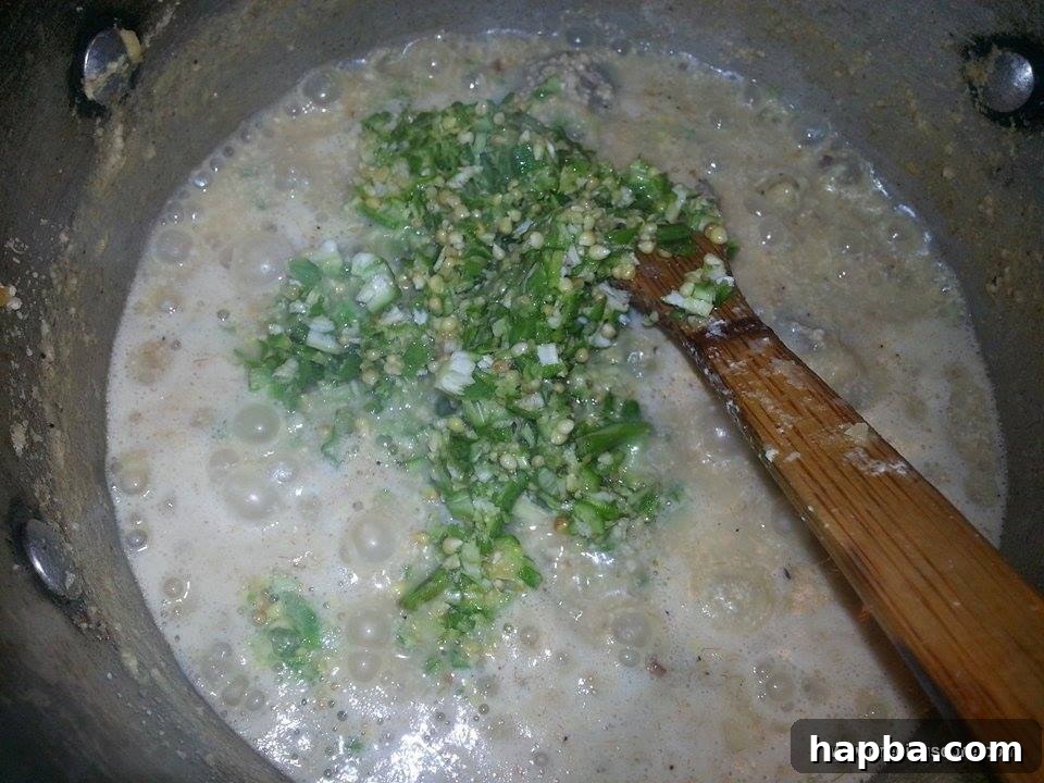 Crafting Delicious Okra Egusi Soup 7 Freshly chopped okra being stirred into the soup