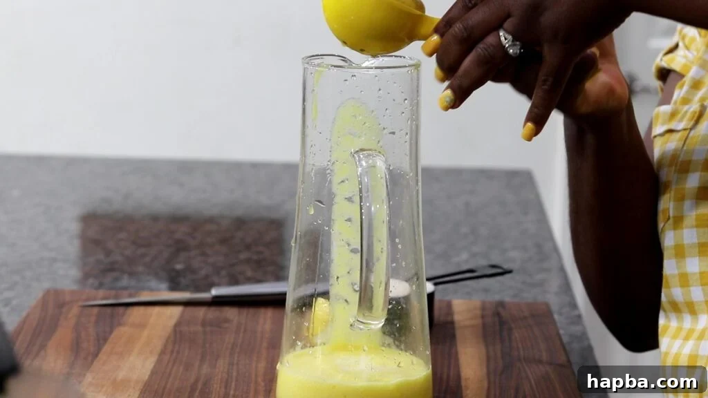 Tropical Zest Lemonade 6 Squeezing lemon juice into a pitcher