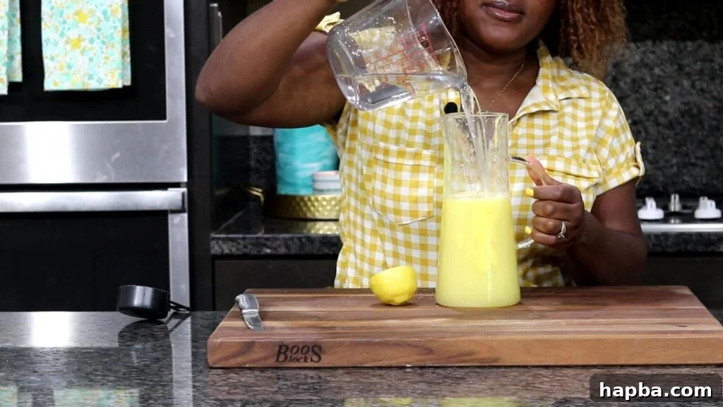 Tropical Zest Lemonade 7 Adding water into a pitcher to complete the lemonade