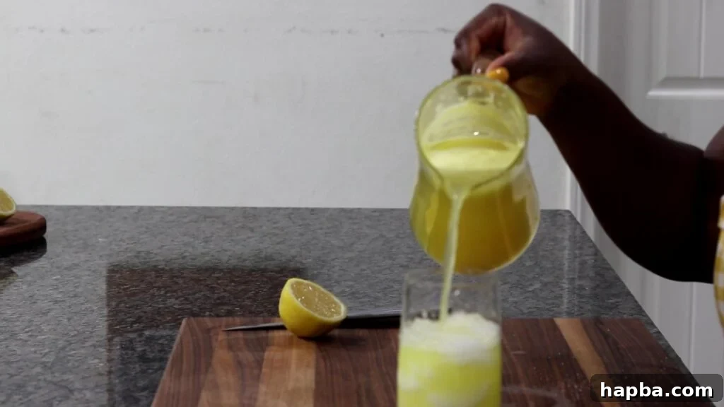 Tropical Zest Lemonade 8 Pouring finished pineapple lemonade over ice