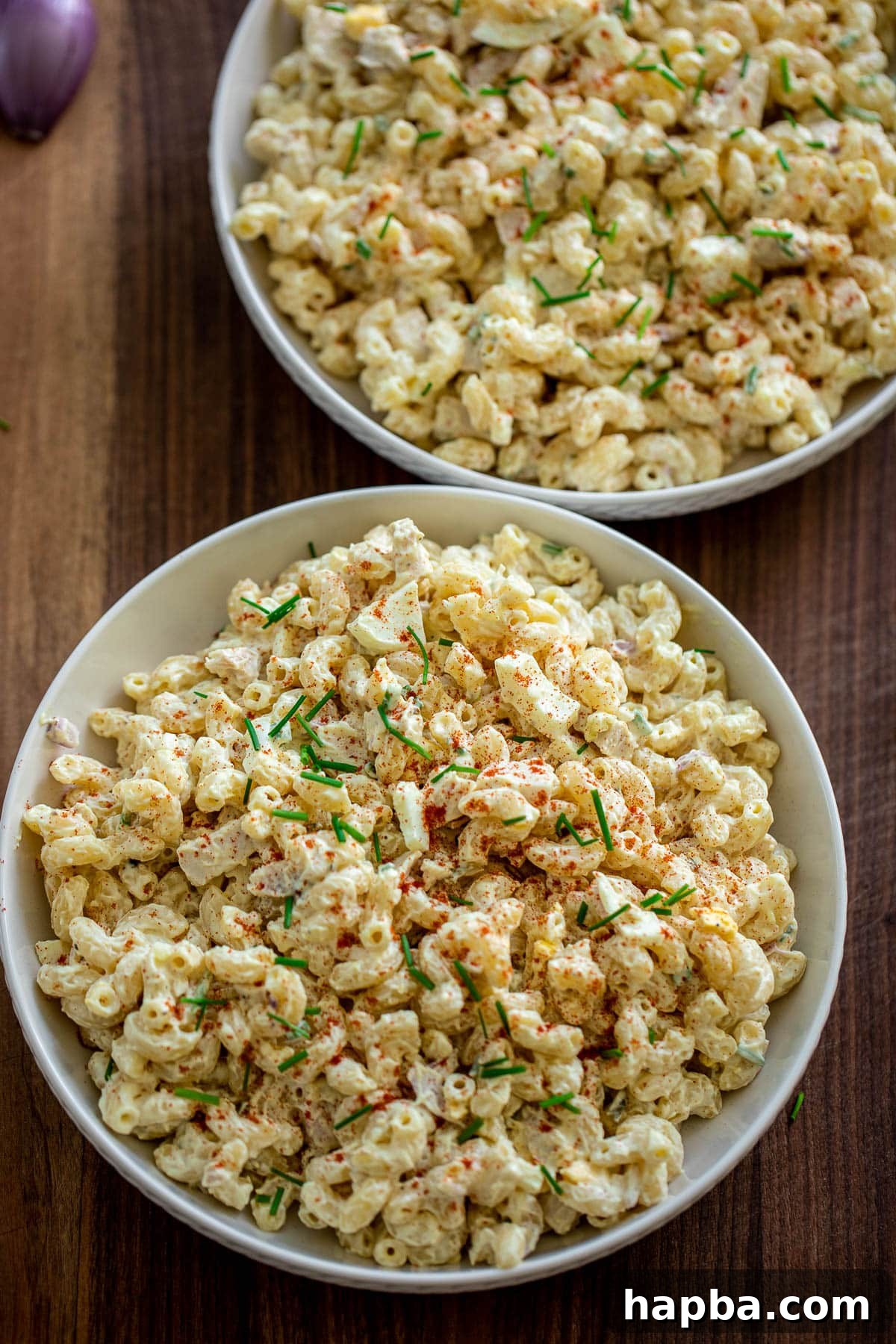 Creamy Chicken Macaroni Delight 9 Two large bowls of creamy chicken macaroni salad, garnished and ready to serve.