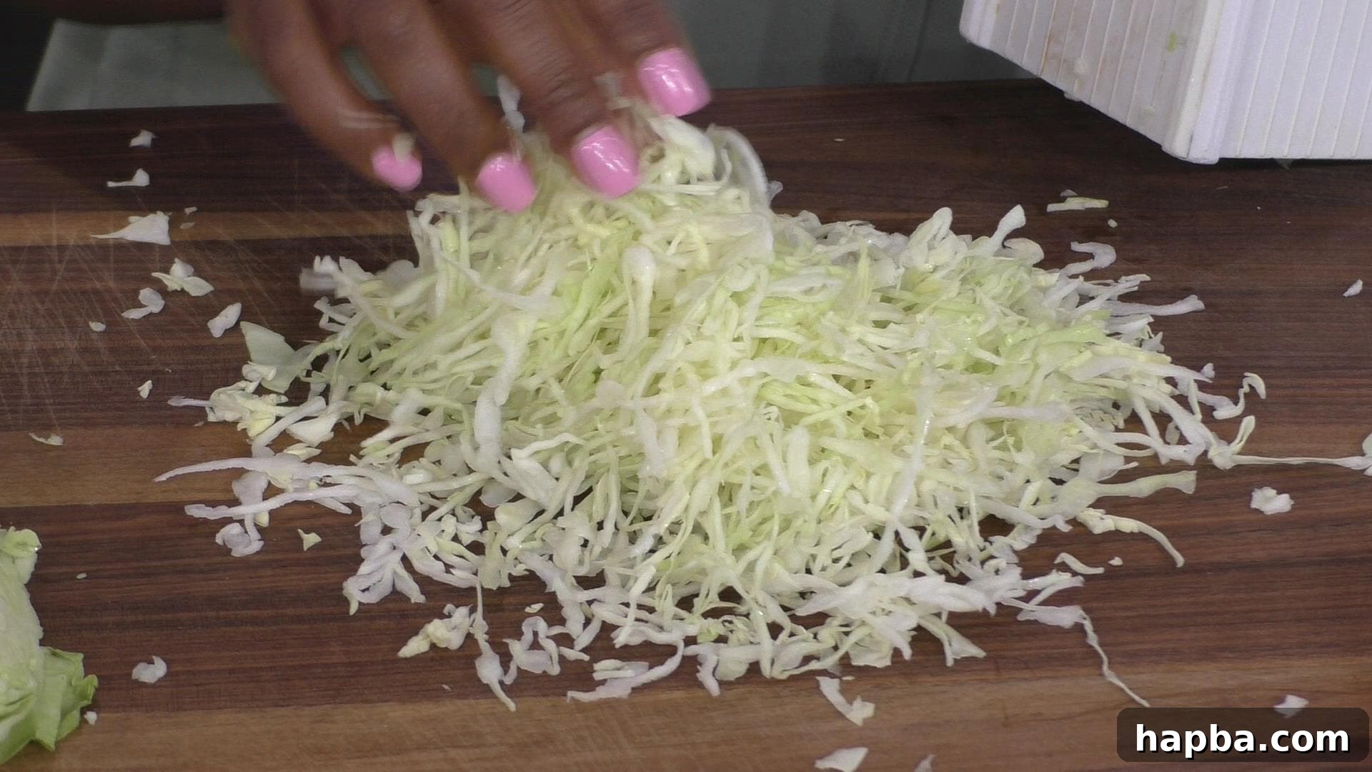 Freshly shredded cabbage, ready for cooking, showing the fine texture achieved with a box grater.
