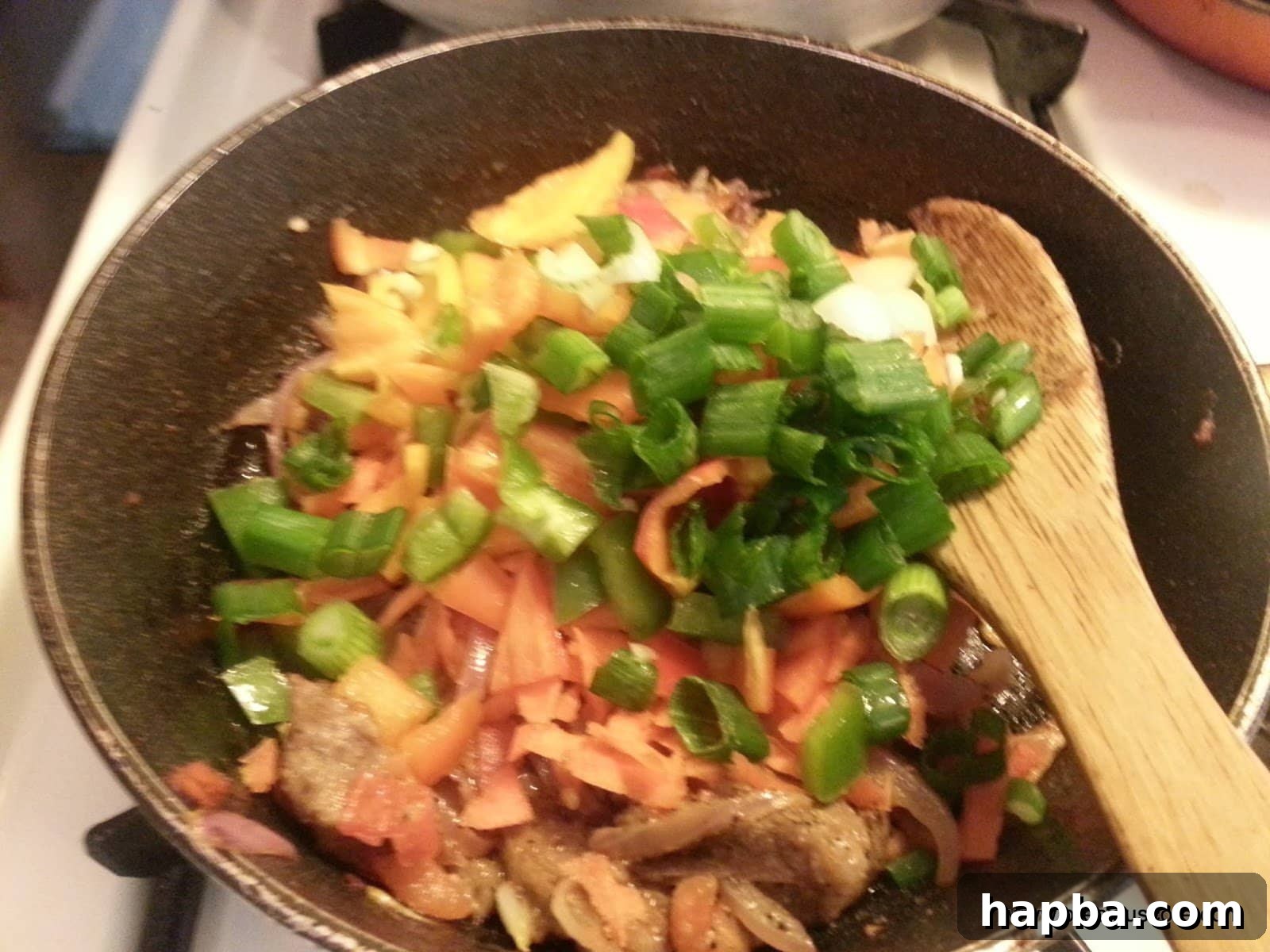 Shredded meat and mixed vegetables added to the savory base in the pan.