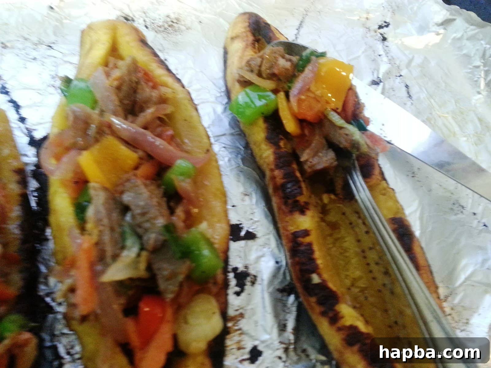 A plantain boat being generously filled with the savory meat and vegetable mixture.