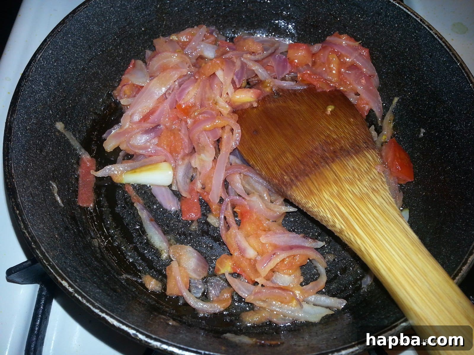 Tomatoes simmering with onions, beginning to soften and meld.