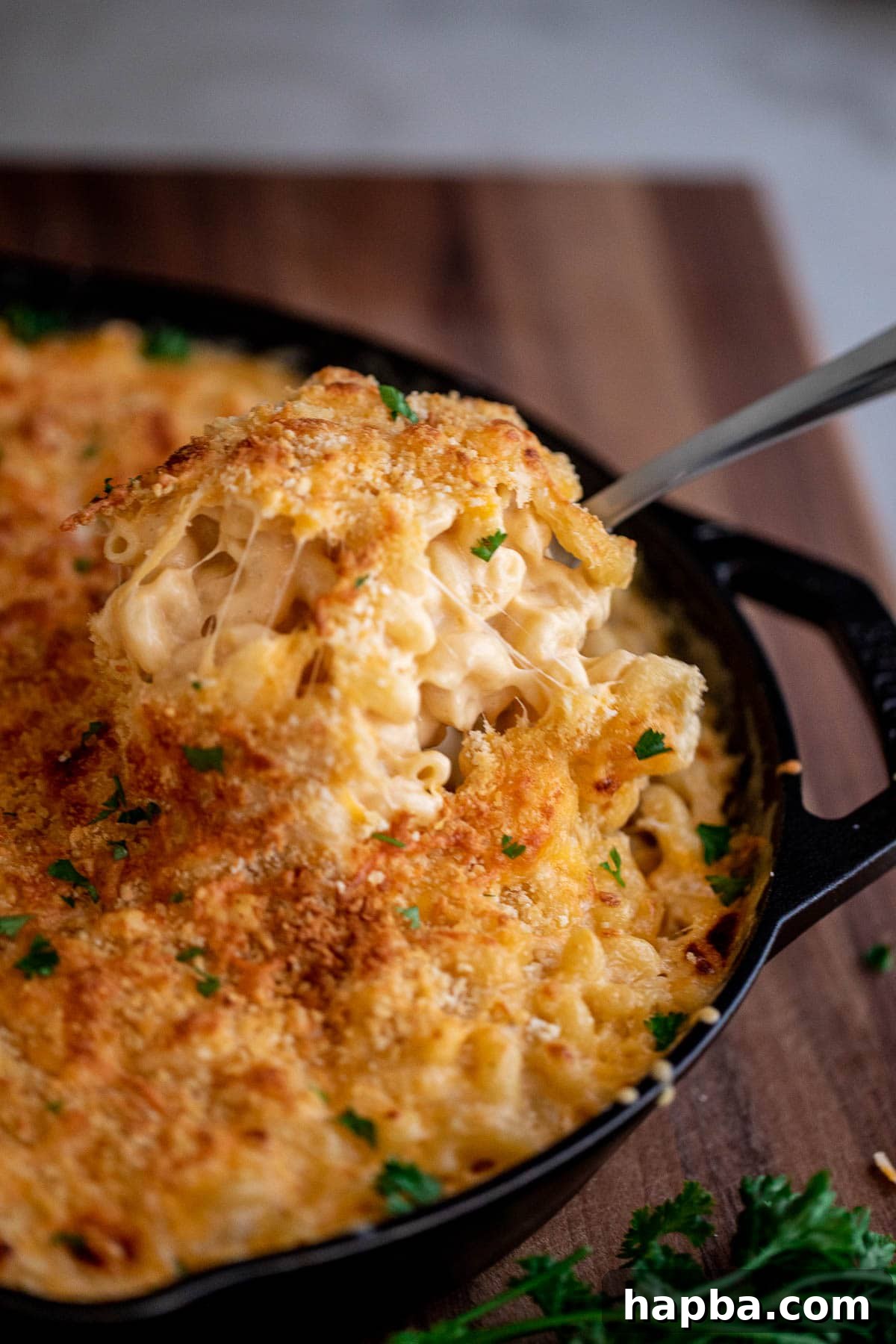 Creamy Triple Cheese Macaroni 2 Spoon lifting up creamy mac and cheese from a bowl
